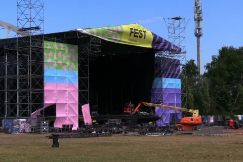 Scena festiwalowa w trakcie przygotowań. Kolorowe banery i konstrukcje zapowiadają nadchodzący fest.