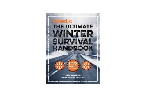 Okładka książki "The Ultimate Winter Survival Handbook" z drogą w zimowym krajobrazie.