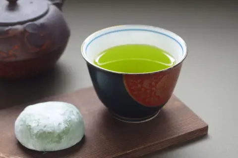 Une tasse de thé sencha bienfaits, avec une touche de mochi vert et une théière japonaise.