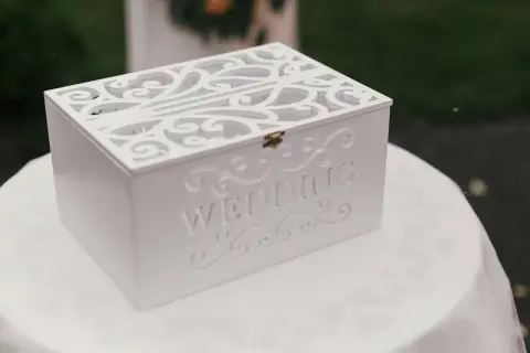 Boîte blanche décorée pour les vœux de mariage, ornée du mot "WEDDING". Une urne élégante pour recueillir les messages des invités.