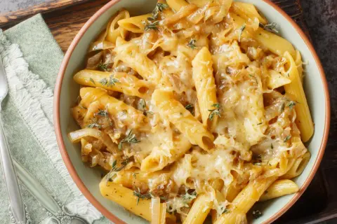 Penne z karmelizowaną cebulą i serem zapieczone w piekarniku. Szybki pomysł na obiad, co można zrobić w piekarniku na szybko.