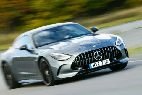 Grå Mercedes AMG GT accelererar på en väg. Lär dig hur startar man en manuell bil och njut av körglädjen.