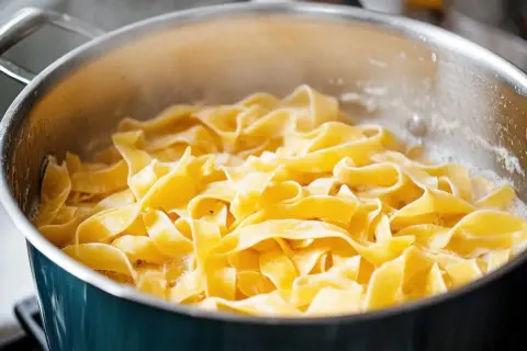 Sączący się z garnka gorący, świeży linguini, gotowy do podania z ulubionym sosem.