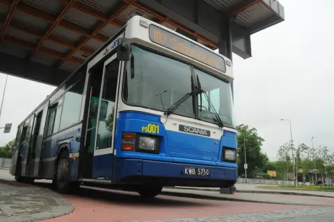 Niebiesko-biały autobus miejski z numerem 107 "Sabanowice" na pętli autobusowej.