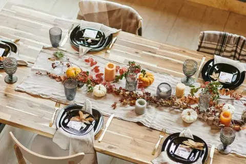 Tischdeko mit Kürbissen, Blättern und Kerzen. Tolle Herbstdeko Ideen für ein gemütliches Essen.
