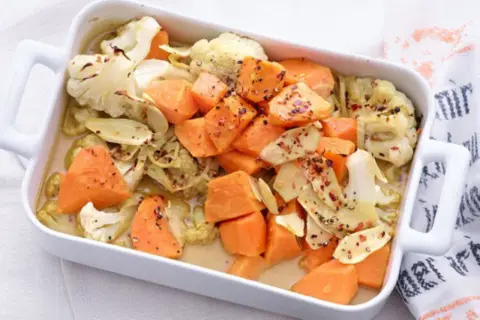 Gebackener Blumenkohl und Süßkartoffeln in einer Auflaufform, ein köstliches Gericht für clean eating rezepte.