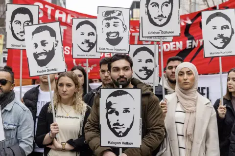 Menschen halten Porträts von Opfern des Hanau-Anschlags hoch. Die Namen der Ermordeten wie Gökhan Gürbüz und Kaloyan Velkov werden gezeigt.