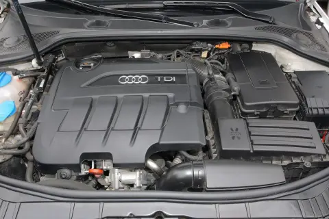 Silnik TDI w Audi A3. Widoczny czarny, plastikowy dekiel z logo Audi i napisem TDI.