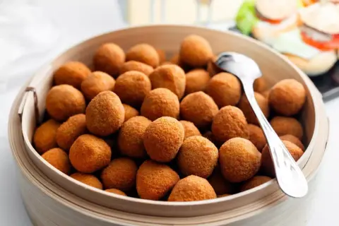 Un cesto di croccanti olive all'ascolana, un classico del cibo marchigiano, pronte per essere gustate.
