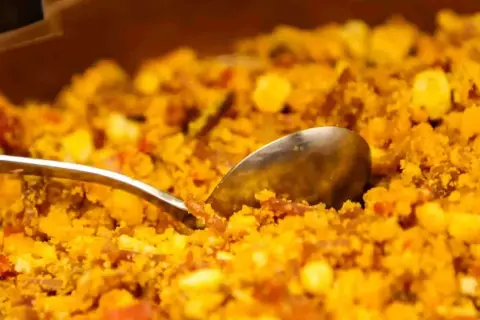 Migas aragonesas, un plato tradicional con trozos de pan, huevo y chorizo, listo para servir con una cuchara.