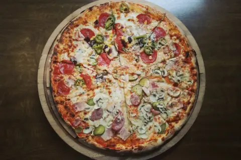 Apetyczna pizza z różnymi dodatkami. Zastanawiasz się, ile kalorii ma kawałek pizzy? Ta wygląda na sycącą!