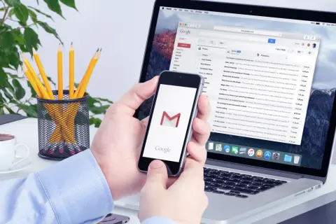 Na tablecie widać ekran Gmail, a obok telefon z ikoną poczty. Jak wylogować się z konta Google na tablecie?