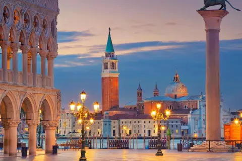 Piazza San Marco Venezia al tramonto, con il Palazzo Ducale, il Campanile e la Basilica di San Giorgio Maggiore illuminati.