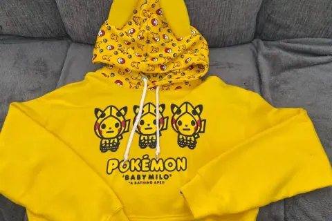 Żółta bluza z kapturem z motywem Pikachu i logiem Pokemon.