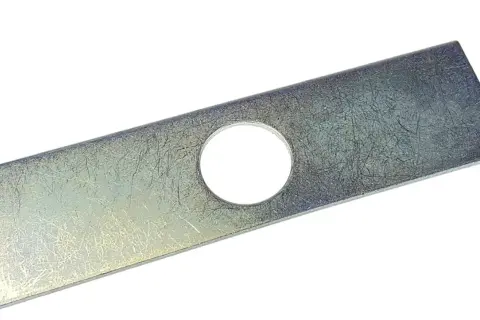 Metalowy nóż do wertykulatora z otworem pośrodku, gotowy do pracy w ogrodzie.