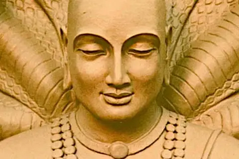Escultura de Patanjali meditando, rodeado por una cobra. Inspiración para los yoga sutras.