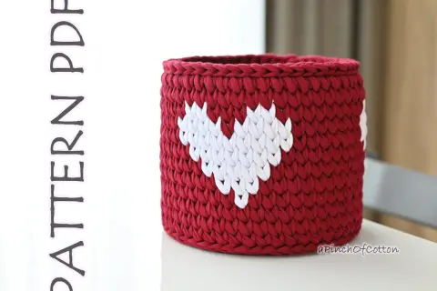 Cestino uncinetto rosso con cuori bianchi, perfetto per decorare la casa o come idea regalo.