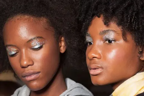 Due ragazze con un trucco scintillante sugli occhi, perfetto per un look da 18 anni. Glitter argentei e colorati illuminano le palpebre.