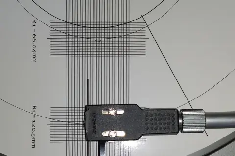 Precyzyjna kalibracja wkładki gramofonowej Sony na szablonie z liniami i wymiarami.