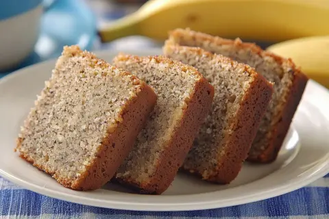 Fredriks fika: saftig banankaka i skivor på en vit tallrik, med en banan i bakgrunden.