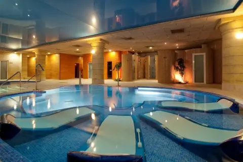 Piscina de hidromasaje con tumbonas integradas, ideal para relajantes sesiones de spa.