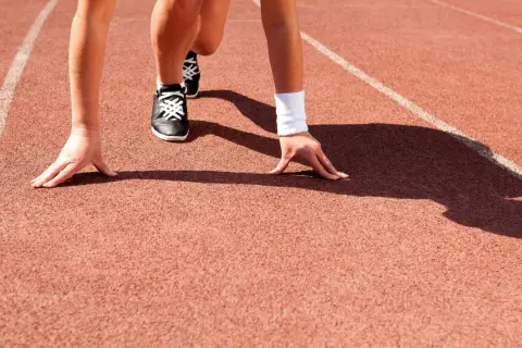 Biegacz na starcie, gotowy do sprintu. Czy to początek wyścigu, czy może symbolizuje, że dnf co to znaczy w sporcie?