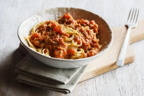 Eine Schüssel Spaghetti mit einer herzhaften, tomatigen Bolognese-Sauce. Perfekt für eine schnelle Bolognese nach einem langen Tag.