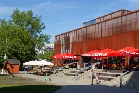 Kraków Klub Studio z czerwonymi parasolami Coca-Cola i schodami prowadzącymi do wejścia.