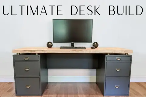A modern DIY computer desk with a light wood top, dark gray drawers, and a monitor setup.