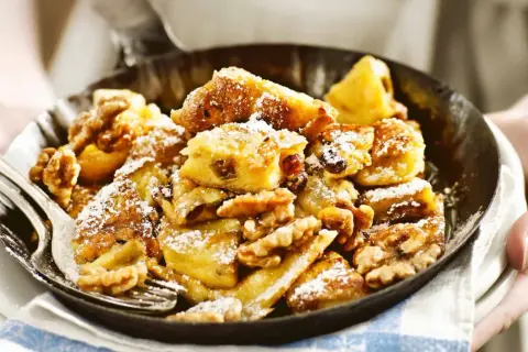 Kaiserschmarrn mit Nüssen und Rosinen, einfach im Thermomix zubereitet, bestäubt mit Puderzucker.