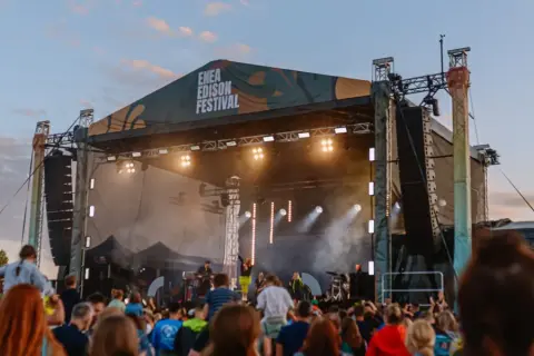 Koncert na Enea Edison Festival. Tłum ludzi przed sceną, na której gra zespół.