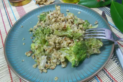 Un délicieux crumble brocolis aux noix, servi sur une assiette bleue.