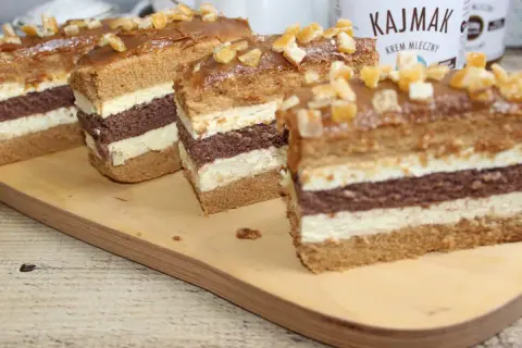 Szybkie ciasto z masą krówkową, przełożone kremem i biszkoptem, ozdobione kandyzowanymi owocami.