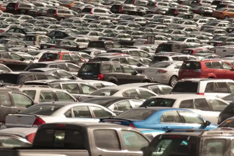 Ogromny parking pełen samochodów różnych marek. Widać wiele modeli, od sedanów po SUV-y, w różnych kolorach.