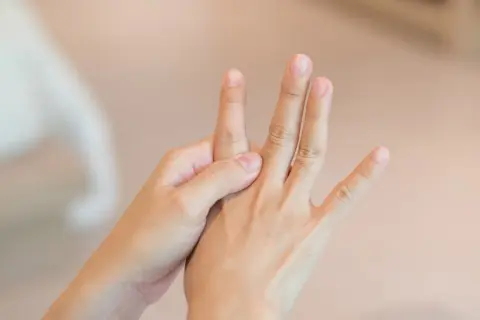 Mani che si massaggiano per alleviare i sintomi della neuropatia alle mani.