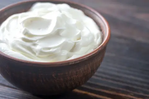 Crème d'Isigny on a wooden table, ready for a delicious crème d'isigny recette.