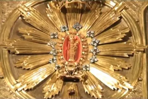 Okładka książki z obrazem Matki Bożej Bolesnej i kościołem w tle.