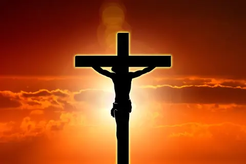 Silhuett av Jesus på korset mot en dramatisk solnedgång. Detta är en stark symbol för vad påsk betyder för många.