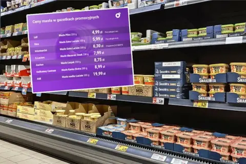 Fioletowa plansza z cenami masła w promocji na tle półek sklepowych z produktami.