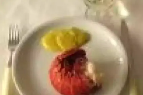 Une langouste rouge sur une assiette blanche avec des tranches de citron. On se demande : peut on manger les œufs de langouste ?