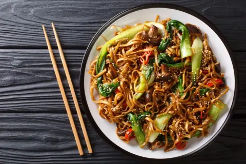 Talerz pełen pad thai z warzywami i grzybami. Zastanawiasz się, ile kalorii ma pad thai?