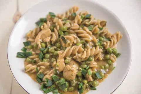 Makaron fusilli z kurczakiem, groszkiem i szczypiorkiem w sosie.