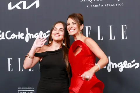 Daniella Bustamante y su hija posan sonrientes en un evento. La joven saluda a la cámara.
