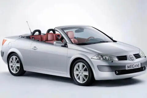 Srebrny Renault Megane cabrio z czerwonymi skórzanymi siedzeniami, gotowy na letnią przejażdżkę.