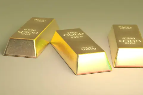 Trzy sztabki złota, każdy o wadze 1000g, z napisem "FINE GOLD 999.9". Ten szlachetny metal lśni w świetle.