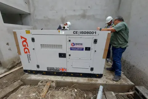 Técnicos revisan un generador eléctrico AGG, esencial para el suministro de energía.