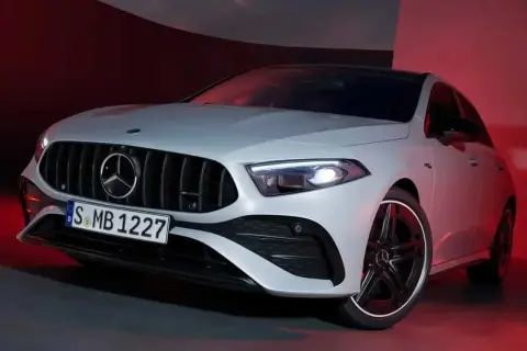 Sportlicher Mercedes A-Klasse mit markantem Kühlergrill und LED-Scheinwerfern, beleuchtet von rotem Licht.