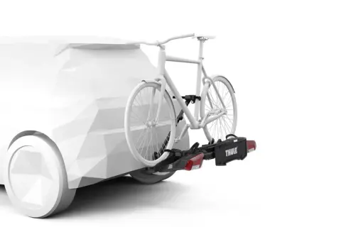 En vit cykel fästs på en dragkrok med en Thule-cykelhållare. Perfekt för att frakta cykeln på semestern.