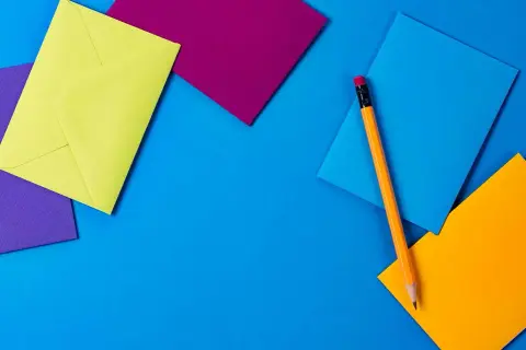 Enveloppes colorées et crayon, prêts pour une sms invitation apéro.