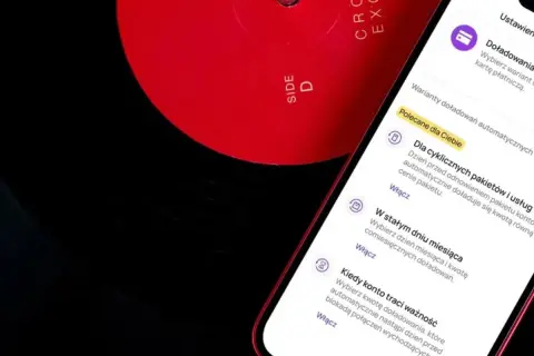 Czerwona płyta winylowa obok smartfona z aplikacją Play.
